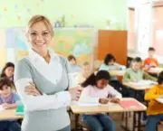 Beautiful smiling female teacher standing and looking at the camera. In the background there is a group of elementary students. [url=http://www.istockphoto.com/search/lightbox/9786682][img]http://img638.imageshack.us/img638/2697/children5.jpg[/img][/url]